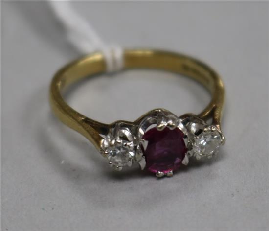 A modern 18ct gold and three stone ruby and diamond ring, size N.